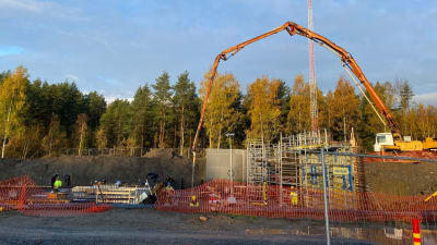 Kran som gjuter cement på arbetsplats. 