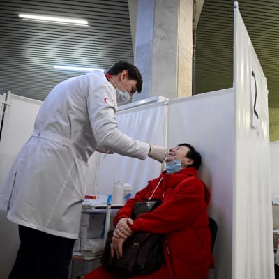 Sairaanhoitaja tekee naiselle koronavirustestin metroasemalla Moskovassa.
