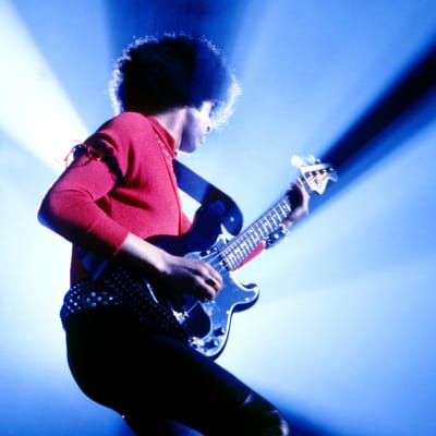 Phil Lynott lavalla basso kädessä, kuvattu sivulta siluettina.