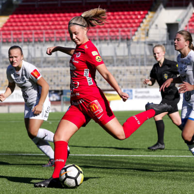 Fotbollsspelaren Ida Adamsson i beredskap att sparka bollen under en match.