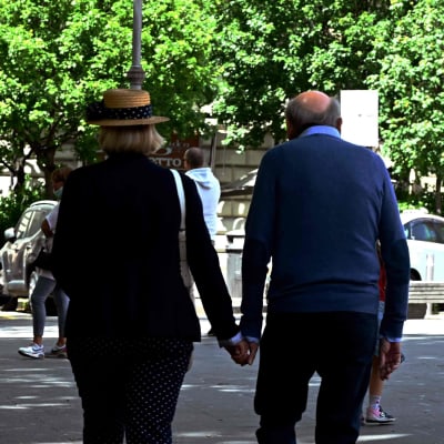 ett äldre par promenerar hand i hand i Rom