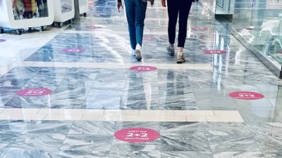 På golvet i ett köpcentrum i Tallinn påminner markeringar hur stort avstånd två meters social distansering är.