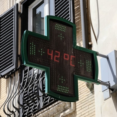 En termometer i ett grönt kors utanför ett italienskt apotek visar 42 grader.