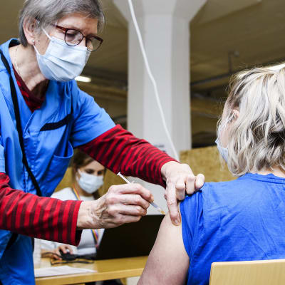 En person som jobbar inom hälsovården får coronavaccin.