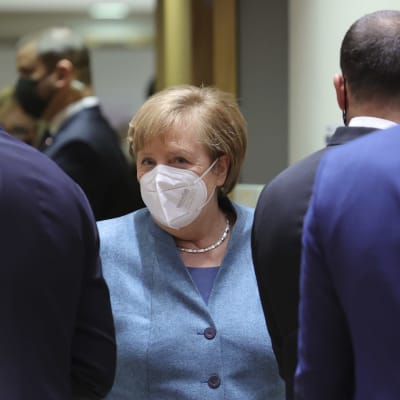 Saksan liittokansleri Angela Merkel kasvomaskiin sonnustautuneena.