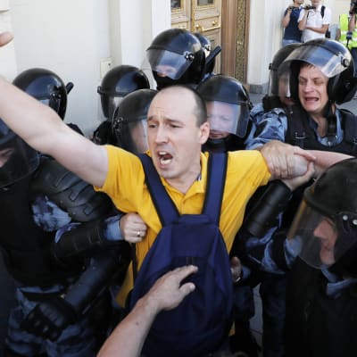 Demonstrant grips av poliser i Moskva. 