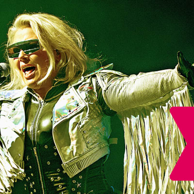 Kim Wilde bär solglasögon och sjunger i en mikrofon.