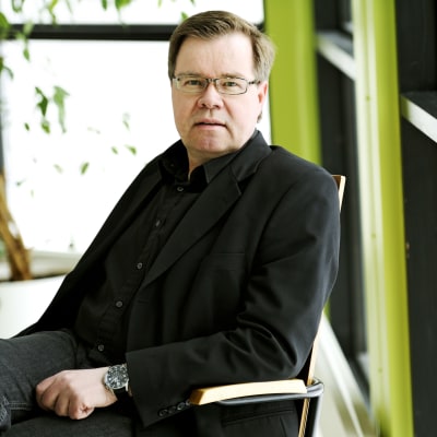 Yle Asian vastaava tuottaja Timo Järvi istuu tuolissa.