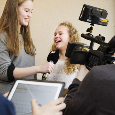 En intervjusituation med en kameraman på plats för att filma.