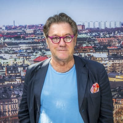 Tommy Körberg i färggranna glasögon och med Stockholm i bakgrunden. 