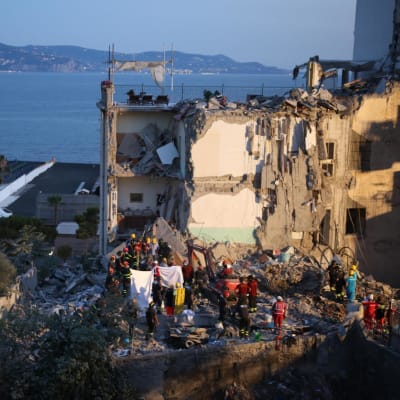 Tiotals brandmän letar efter överlevande kring huset som rasade i Neapel.