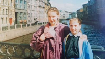 Kirjailija Anna Soudakova 10-vuotiaana äitinsä kanssa käymässä Pietarissa. Poseeraavat  sillalla, taustalla kanava ja vanhoja rakennuksia.