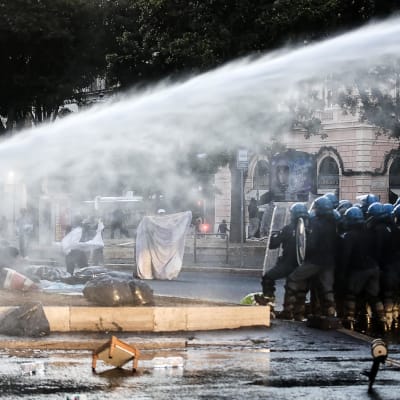 Kravallpolis använde bland annat vattenkanoner då de vräkte migranter som hade slagit läger på ett torg i Rom   