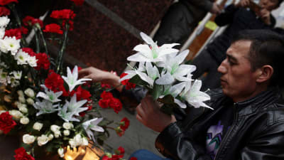 Rysk man placerar blommor efter terrorattacken i S:t Petersburg den 3 april.