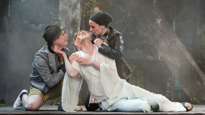 Helena omgiven av Demetrius och Lysander i Ryhmäteatteris uppsättning av En midsommarnattsdröm.