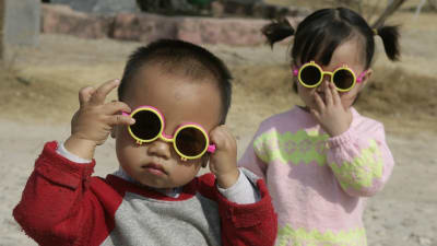 Två sm¨å barn med solglasögon.