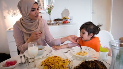 En muslimsk kvinna med sin dotter äter kvällsmålet iftar under ramadan.