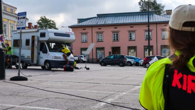 Bild av en kille som har hoppat upp på¨vindrutan på en husbil på torget i Ekenäs. 