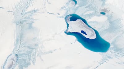 En satelitbild på grönlandsisen. I mitten syns en större vattenmassa där isen smält och bildat något som liknar en sjö.