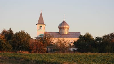 En av kyrkorna i Gammalsvenskby i södra Ukraina. Kvällsol, kyrkan har kompletterats med en lökkupol.