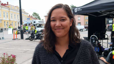 Porträtt av Inka Hietala framför filminspelningsplatsen på Ekenäs torg. 