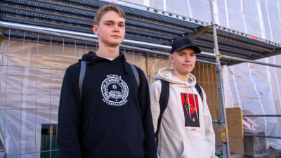 En bild på två elever från Borgå Gymnasium som tittar mot kameran. De står utanför Borgå Gymnasium.
