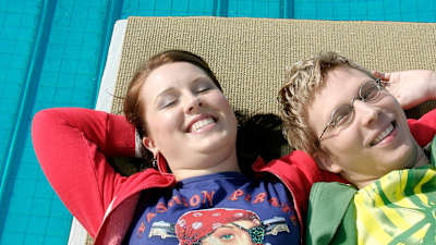 Titte Neuvonen ja Nuutti Takkinen makaavat selällään uimahyppytornin hyppyalustalla. Aurinko valaisee molempien kasvot.
