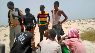 Överlevande migranter på en strand i södra Jemen. Runt 100 flyktingar befaras ha drunknat utanför Jemens kust efter att ha tvingats i havet av människosmugglare. 