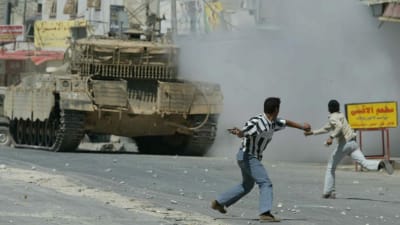 Palestinska ungdomar kastar sten på israelisk pansarvagn i Askar nära Nablus på Västbanken.