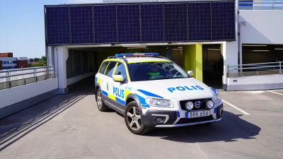 En svensk polisbil som kör i ett parkeringshus