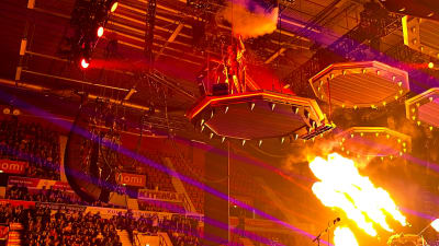 Kiss Gene Simmons uppträder på podium i takkanten i ishall med eld och ljusshow.
