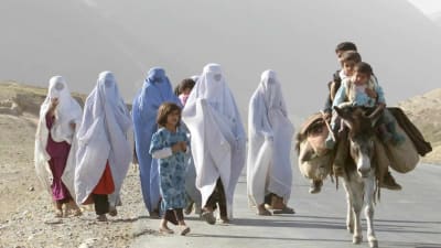 En grupp afganska flyktingar på en väg någonstans.