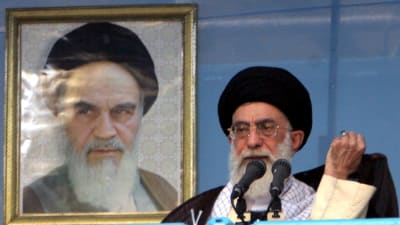 Ayatolla Ali Khamenei talar, ayatollah Khomeini i bakgrunden
