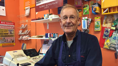 Köpman sitter i kassan i butik