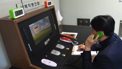 En sydkoreansk regeringstjänsteman kommunicerar med en nordkoreansk kollega över den "heta linjen" i gränsstaden Panmunjom den 3 januari.