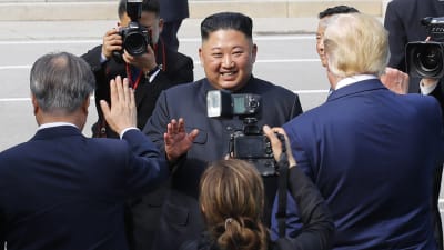 Nordkoreas ledare Kim Jong-un ler brett framför kamerorna. 