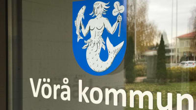En närbild av dörren till Vörå kommungård som föreställer kommunvapnet.