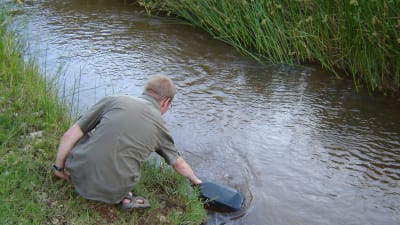 Magnus Dahlbacka hämtar vatten i floden. 