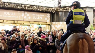 Polis på häst håller ett öga på publik under öppningen av julgatan i Helsingfors.