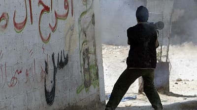 En Hamasaktivist siktar på en israelisk pansarvagn i Jabaliya i Gaza.