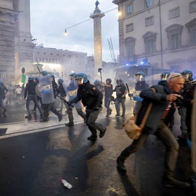 Demonstranter och polis springer på gatan i Rom i ett moln av tårgasrök.
