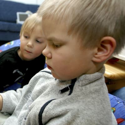 Två pojkar tittar på en mobiltelefon