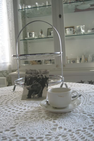 Kekkonens odiskade kaffekopp och ett fotografi på presidenten inlindad i en filt. Fotot taget i samband med invigningen av Metsä-Botina 1975 i Kaskö.