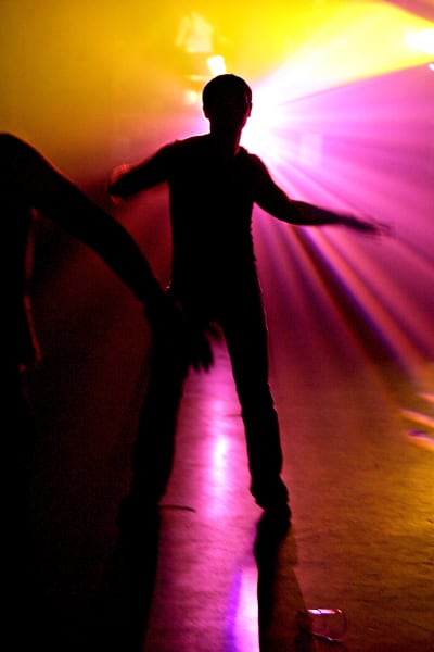 Tanssi. Mies tanssii tanssilattialla, värivalot. Disco. Siluetti.