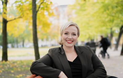 Kvinna som ler tittar in i kameran. 