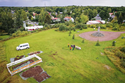 Vy över Korsholms vallar, grönt gräs och minnesmärke.