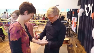 En kvinna ber att en musiker skriver sin autograf med en tuschpenna på kvinnans arm.