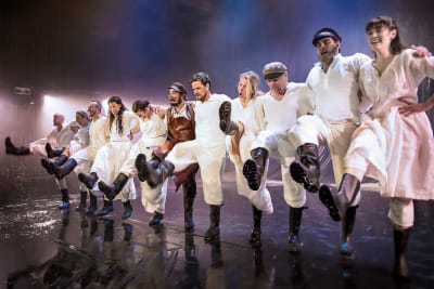 En rad människor dansar på en scen.