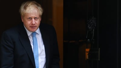 Premiärminister Boris Johnson i kostym och blå slips. Till höger en dörr.