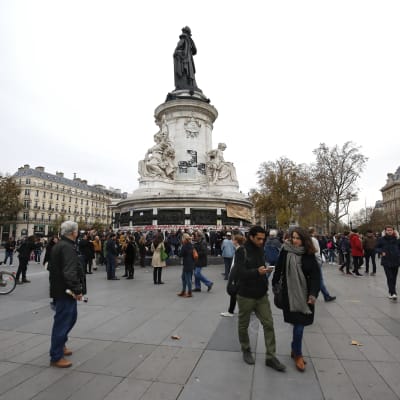 Folk lägger blommor vid Place de la Republique i Paris.